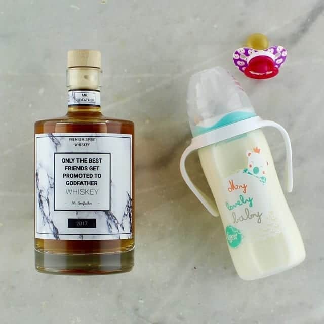 Fles whisky met marmeren patroon label en opschrift "Only the best friends get promoted to Godfather"