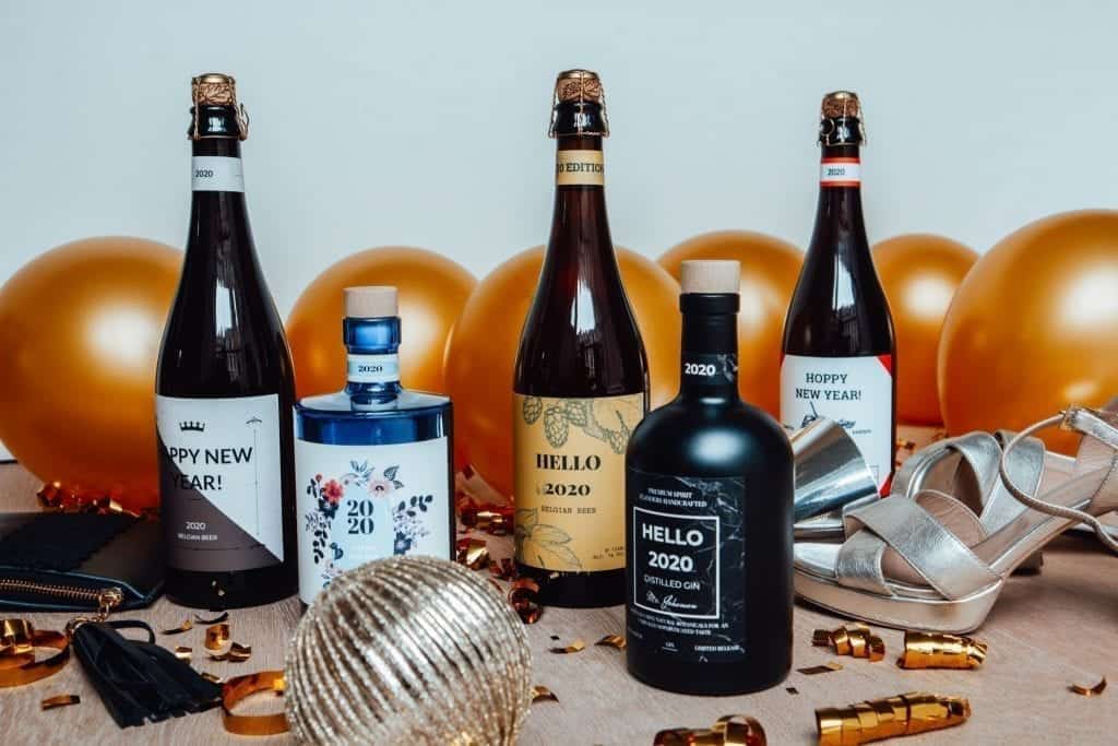 gepersonaliseerde flessen gin of bier die in een nieuwjaars setting staan