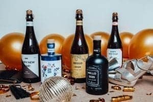 gepersonaliseerde flessen gin of bier die in een nieuwjaars setting staan