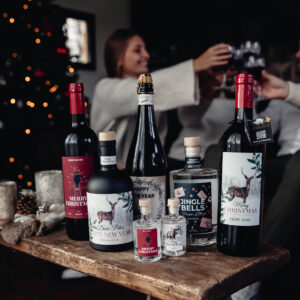 gepersonaliseerde flessen op tafel met klinkende mensen