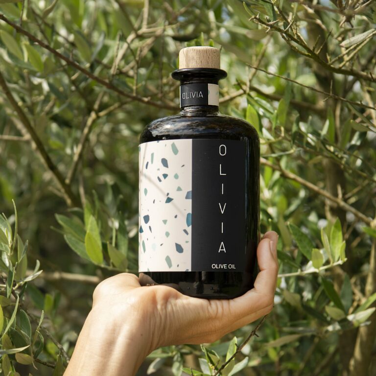 olijfoliefles naast olijfboom