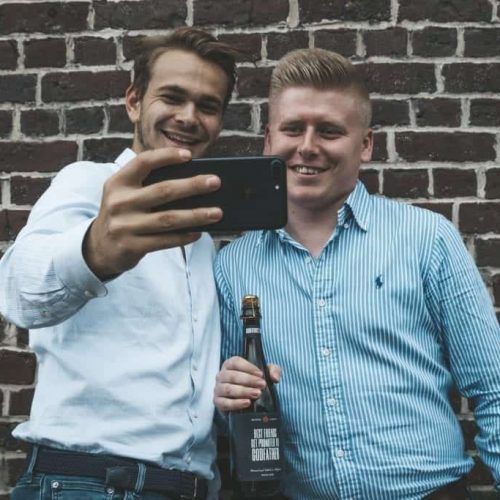 Twee mannen houden een fles bier vast als peter vragen cadeau